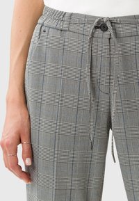 Pantalons à carreaux gris avec taille élastique et fermeture à boutons. Présente un motif check avec des accents bleus et une texture douce.