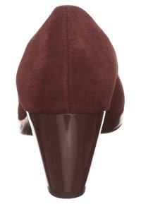 Burgundy mockaläder hög klackskor med rund tå och glänsande plastklack. Slät textur med subtila sömnadsdetaljer längs bak.