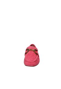 Mocassino in suede rosa con punta arrotondata, caratterizzato da un dettaglio in metallo color oro a forma di bit di cavallo sulla parte superiore. Texture morbida e design minimalista.