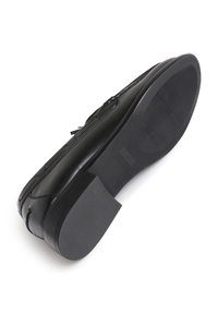 Zwarte leren schoen met een gladde textuur, ronde neus en een rubberen zool. Kenmerkt zich door een contrasterende gestikte detail en een lage hak.