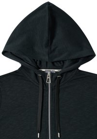 Sweat à capuche noir zippé avec cordon réglable, tirant de fermeture éclair en métal et étiquette "SUNKISSED SOUL" à l’intérieur du col.