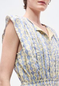 Φόρεμα με λουλουδάτο μοτίβο σε κίτρινο και ανοιχτό μπλε, με γιακά, αμάνικο σχέδιο και ζώνη στη μέση για εφαρμοστό σχήμα.