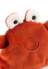 Orange plush toy with a smiling face. Features large white eyes with black pupils and textured fabric, including smooth and fuzzy areas.