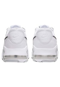Witte Nike Air sneakers met mesh en leren texturen, voorzien van een heldere luchtzool, een reliëflogo op de hiel en grijze accenten.