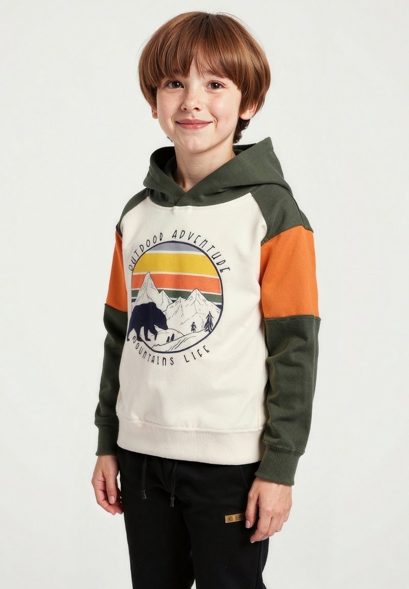 Mikina s kapucí má krémovou barvu těla, zelené rukávy a oranžové akcenty. Obsahuje grafiku s horami a medvědem. Má měkkou texturu a volný střih.