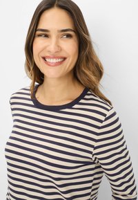 Gestreepte longsleeve top in crèmekleur met marineblauw, met een ronde hals en zachte stof. De strepen zijn gelijkmatig verdeeld, wat een klassieke uitstraling creëert.