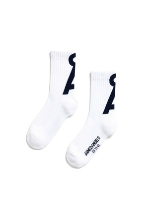 Chaussettes de sport blanches avec des cuffs côtelés, arborant un grand numéro graphique bleu marine de chaque côté, et un texte de marque bleu marine sur la semelle.