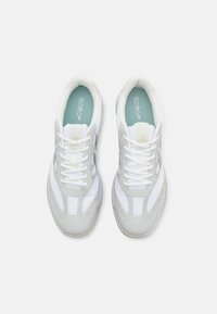 Weiße Sportschuhe mit einem strukturierten grau-weißen Design, Netzpaneelen und kontrastierenden Akzenten, mit Schnürsenkeln und gepolstertem Kragen.