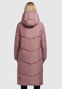 Lange, gewatteerde pufferjas met kap in zacht roze, met een gearceerde textuur en chevronsteek, en een logopatch aan de zoom. Soepel, lichtgewicht materiaal.