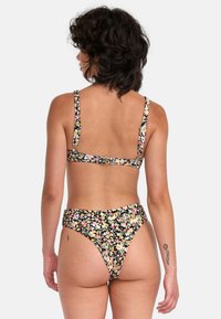 Ensemble de bikini floral avec un fond noir et des motifs floraux colorés. Bretelles ajustables, dos à crochet et bas taille haute.