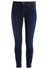 Ciemnoniebieskie obcisłe dżinsy o gładkiej fakturze, z pięcioma kieszeniami, zapięciem na guziki i suwakami przy kostce dla regulowanego dopasowania.
