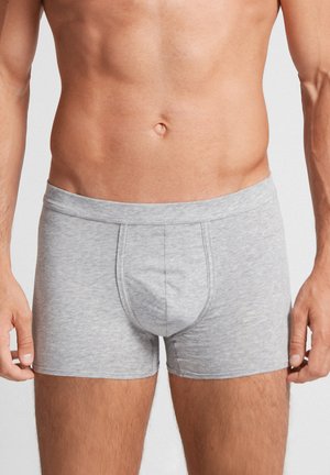 Graue Baumwoll-Boxershorts mit weicher Textur, elastischem Bund und einer vorderen Tasche. Sie verfügen über eine glatte Oberfläche mit minimalen Nähten.