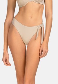 Bikini z wysokim stanem w jasnym beżowym kolorze, o gładkiej, błyszczącej strukturze i z detalem w postaci wiązania z boku dla łatwej regulacji.