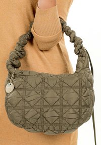 Olijfgroene doorgestikte handtas met een gestructureerde afwerking, voorzien van een gedraaide band en een zilverkleurig sierlabel. Het ontwerp heeft een ruitpatroon.