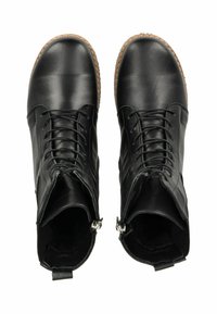 Botas de tobillo de cuero negro con acabado brillante, diseño con cordones, cremalleras laterales y suelas de goma texturizadas. Parte superior lisa con acentos mínimos.