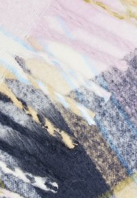 Couverture tissée avec des motifs multicolores dans des teintes pastel de rose, bleu, crème et marine. Tissu texturé avec des bords frangés. Apparence douce et confortable.