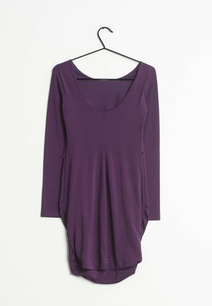 Robe longue à manches longues de couleur violette avec un décolleté en U, fabriquée en tissu lisse. Caractérisée par des côtés froncés et un ourlet incurvé. Suspendue à un crochet noir.