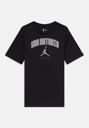 Juodas medvilninis marškinėliai su užrašu "SAN ANTONIO" ir šviesiai pilku Jumpman logotipu. Trumpomis rankovėmis ir apvalia iškirpte. Paprastas, klasikinis dizainas.