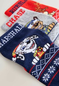 Three pairs of children's socks in soft knit: red with reindeer, gray with a dog, and navy featuring a dalmatian with patterned accents.