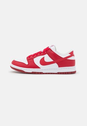 Niski sneaker z czerwonej i białej skóry z czerwonymi sznurowadłami i podeszwą, z widocznym czerwonym logo swoosh po boku.