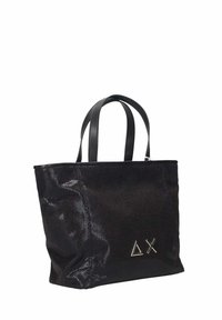 Borsa tote nera in materiale sintetico con texture liscia, doppi manici, forma quadrata e dettagli in metallo a forma di triangolo sulla parte anteriore.