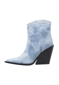 Botín de denim en azul claro con punta afilada, tacón alto negro tipo cuña y costuras decorativas. Textura suave y sin patrones visibles.