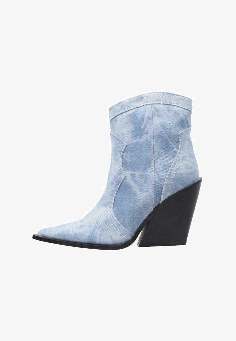 Botte à cheville en jean bleu clair avec un bout pointu, un talon compensé noir haut et des coutures décoratives. Texture lisse et aucun motif visible.