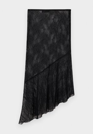 Jupe asymétrique en dentelle noire transparente avec motif floral et ourlet diagonal superposé, présentée sur un fond clair uni.