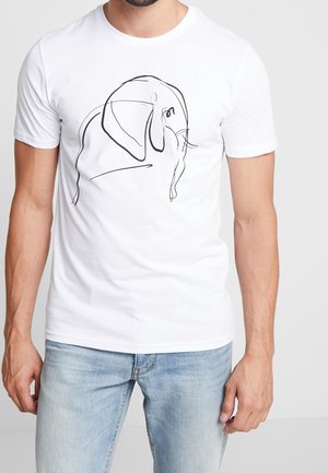 Homme portant un t-shirt blanc avec un dessin simple au trait noir d'un éléphant sur le devant, associé à un jean bleu clair.