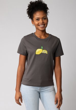 T-shirt en coton gris avec un col rond, présentant un graphisme de citron en jaune et vert sur le devant. Manches courtes, coupe décontractée.
