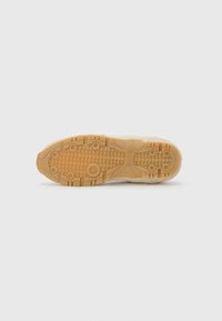 Suola della scarpa con un design testurizzato. Materiale beige chiaro, caratterizzato da motivi circolari e a onda, e una suola in gomma per una migliore aderenza.