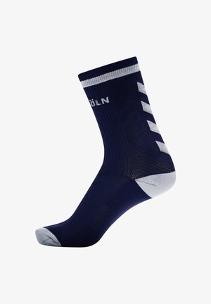 Mørkeblå sok med ribbet tekstur, hvide striber øverst og forstærket tå. Har diagonale hvide accenter på siden.