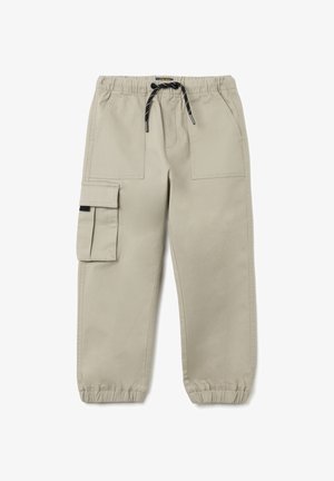 Pantalones cargo beige con una cintura elástica, cierre con cordón y puños ajustados. Presentan múltiples bolsillos y una textura suave.