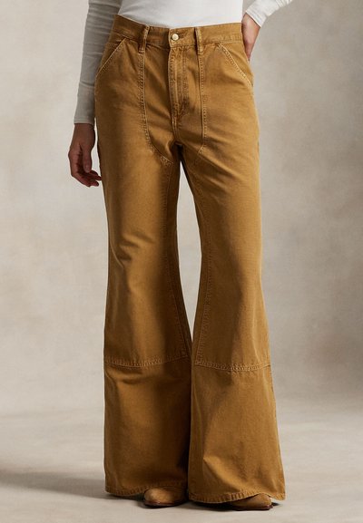 Pantaloni cu picioare largi într-o nuanță caldă de maro, realizați din bumbac; prevăzuți cu buzunare frontale, cusături contrastante și design cu talie înaltă.