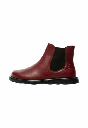 Bota Chelsea de cuero roja única con panel lateral elástico negro y suela negra, vista desde el perfil exterior.