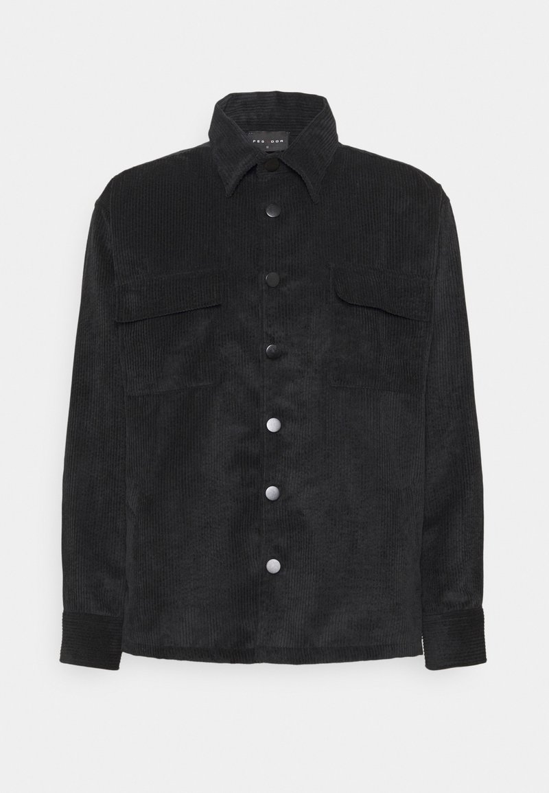 Giacca camicia di velluto a coste nera con chiusura a bottoni, due tasche sul petto, colletto classico e tessuto testurizzato. Bottoni in tono argento come dettaglio.