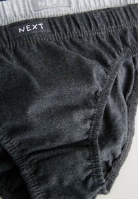 Dunkelgraue Baumwollslips mit weicher Textur, ausgestattet mit einem elastischen Bund und gesteppten Details. Das Markenlabel "NEXT" befindet sich am Taillenbund.