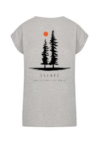 Gray t-shirt featuring a black silhouette of two pine trees and an orange sun. Text below reads "ESCAPE AND DISCOVER THE WORLD."
