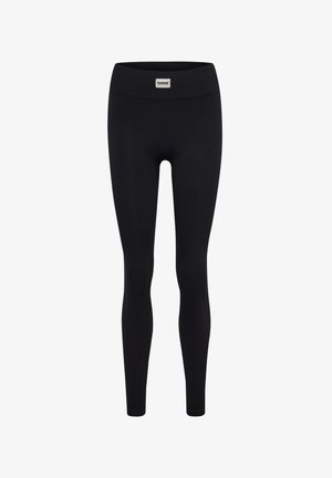 Leggings noirs côtelés avec une large taille élastique et une petite étiquette de marque à l'avant. Le tissu semble extensible et lisse.