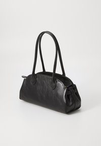 Schwarze Lederhandtasche mit glatter Textur, runder Form, zwei langen Tragegriffen und Reißverschluss. Mit subtiler Krümmung an den Seiten.