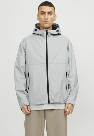 Hellgraue wasserdichte Jacke mit Kapuze, schwarzem Reißverschluss und seitlichen Taschen. Sie verfügt über ein strukturiertes Gittermuster und verstellbare Kordeln.