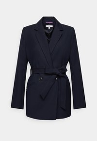 Námořnický modrý blazer s páskem v oblasti pasu, dvojitým zapínáním a klopovými límci. Vyrobeno z hladkého materiálu, s bočními kapsami.