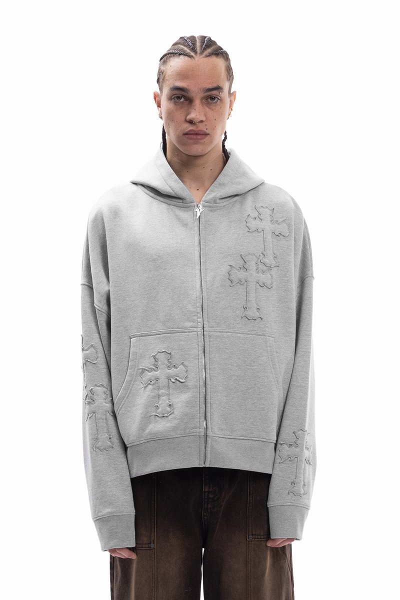 Γκρι ζακέτα με φερμουάρ από απαλό ύφασμα, με κεντημένα μοτίβα σταυρών και τσεπάκι καγκουρό. Χαλαρή εφαρμογή με κουκούλα και ριμπ μανσέτες.