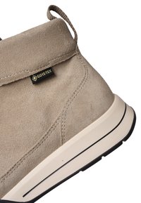 Beiger Wildleder-Stiefelette mit Gore-Tex-Etikett, dicker weißer Sohle mit schwarzer Linie und Lasche an der Ferse.