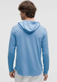 Lichtblauwe hoodie met lange mouwen, gemaakt van een gestructureerde stof, met een capuchon, lange mouwen en een rechte zoom. Subtiele merkdetails aan de zijkant.