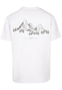 Witte katoenen t-shirt met een zwarte illustratie van een berglandschap met bomen en tekst eronder, relaxte pasvorm en korte mouwen.