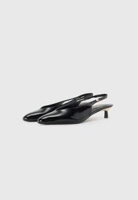 Scarpe slingback in vernice nera con punta affusolata, tacco a stiletto basso e una fascia sul retro per una vestibilità sicura.