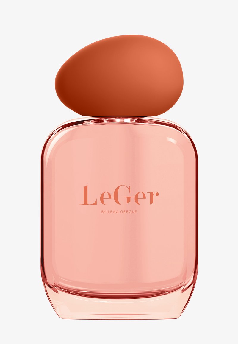 Różowa szklana butelka perfum z zaokrągloną pomarańczową zakrętką. Etykieta na przodzie głosi "LeGer by Lena Gercke" w jasnej czcionce.