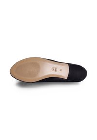 Schwarze Stoff-Ballerschuhe mit beigem Gummisohlen, die eine glatte Textur und ein dezentes Rillenmuster für bessere Traktion auf der Unterseite aufweisen.