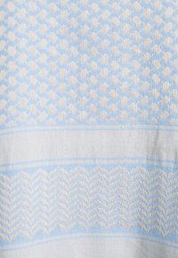 Gewebter Stoff mit einem hellblauen und beigen Muster aus ineinandergreifenden Kurven und Zickzack-Streifen. Weiche Textur mit glatter Oberfläche.